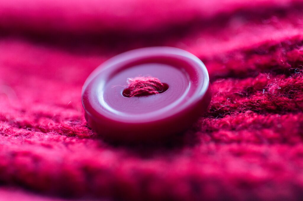 close up of button sewn to knitted item