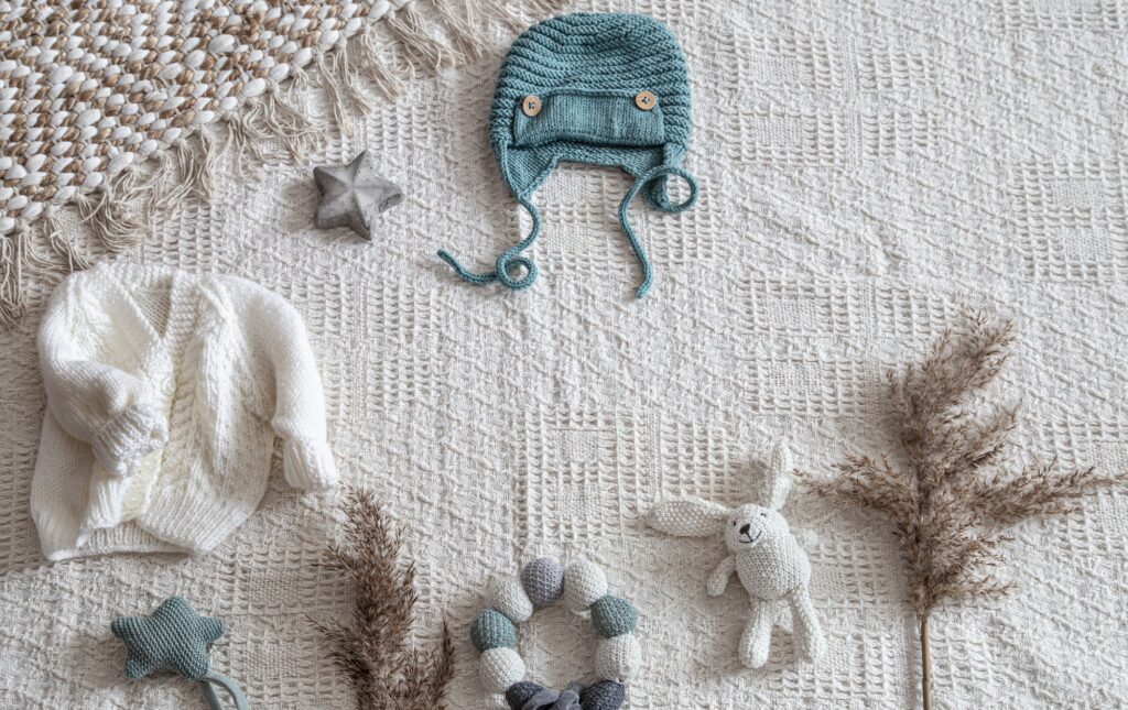 Knitted children's clothing on a light background with accessories