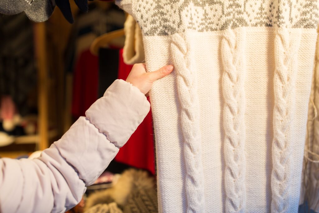 woman buying woolen clothes at christmas market