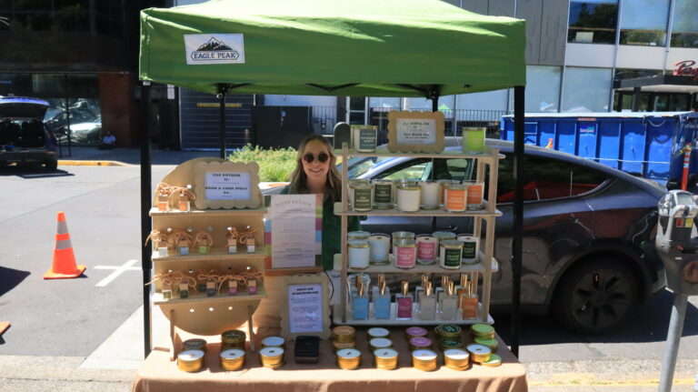 Vendor booth displaying jars, bottles, soaps, and other bath and body products at The Saturday Market